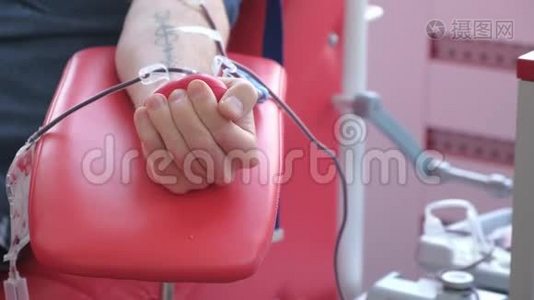 一个人在输血中心献血时挤压一个球。视频