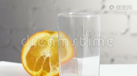 鲜榨的橙汁倒在桌子上的玻璃杯里，旁边放着几片橘子。 新鲜黄色饮料视频