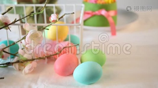 春季复活节节日餐桌。 背景上有黄油奶油花和五颜六色的鸡蛋的小绿色蛋糕。 女人的手视频
