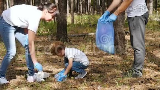 幸福家庭在森林里收集垃圾。 妈妈和孩子把垃圾放进一个可生物降解的袋子里。 教育儿童视频