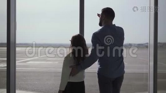 在跑道上的玻璃机场门外`白种人男子和小女孩的背影。 父亲和视频