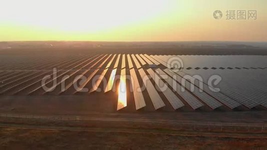 在明亮的夕阳下，空中无人机在太阳能农场观看大型太阳能电池板。 太阳能电池发电厂。 录像4K。视频