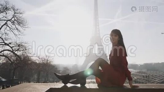 在巴黎埃菲尔铁塔的夕阳下，美丽快乐的女人微笑着摆着红色的裙子视频