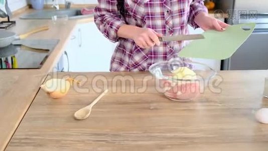 家庭主妇在碗中加入切碎的肉，然后是鸡蛋、洋葱和盐。视频