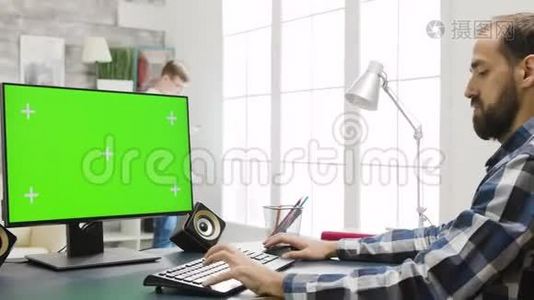 在舒适明亮的客厅里使用绿色屏幕的个人电脑显示器视频