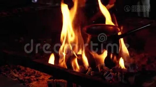 带咖啡的土耳其人站在被红色火焰包围的煤块上，在火上煮视频