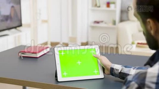 一个人滚动触摸一个绿色屏幕的数字平板电脑视频