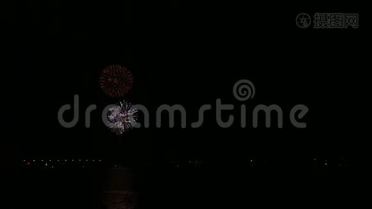 明亮闪闪的节日烟花在夜空上的河流反射在水中。视频