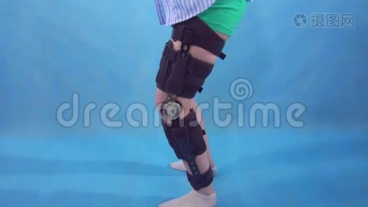 一位年轻女子受伤后蹲着膝盖弯曲，膝盖支撑蓝色背景视频