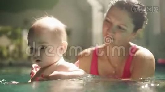 高兴的白种人母亲和她的小男孩正在室内游泳池里游泳，在水下挥手。 儿童视频