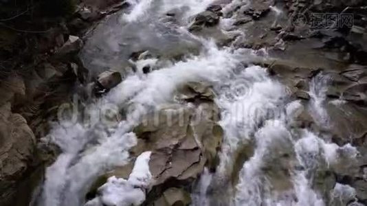 冬天的瀑布普鲁特。 从山溪和带雪的石急流中快速流出的水视频