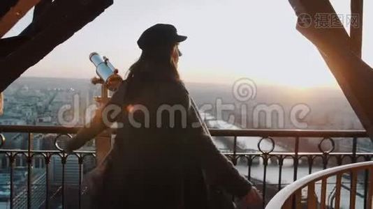 美丽的年轻女子在埃菲尔铁塔顶部摆姿势和旋转，欣赏史诗般的日落巴黎天空全景慢动作。视频