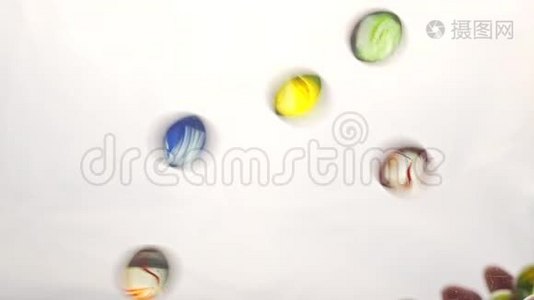从下面的视图，因为手抛出小的多色塑料球。 白色背景。视频