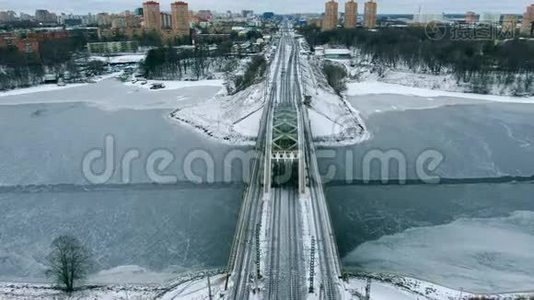 鸟瞰美丽的城市景观铁路大桥，跨越冰冻的河流视频