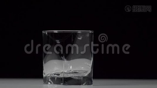 工作室拍摄的可乐倒入透明玻璃在白色的桌子上。视频