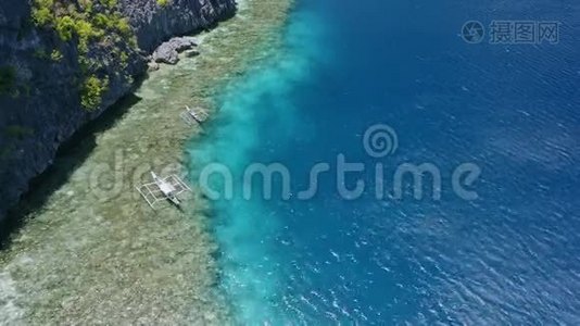 banca旅游船停泊在珊瑚礁边缘的空中镜头。 菲律宾巴拉望视频