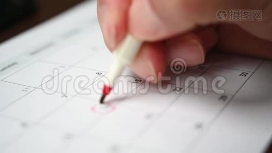 慢动作。 一个人手里拿着一支笔，把他的日程记录在桌历上视频