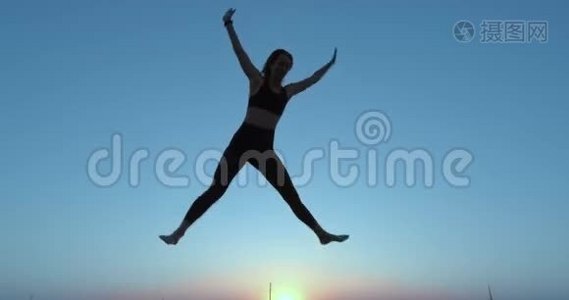 一个女孩在蹦床上跳得很高。 对着天空。 积极的生活方式。视频