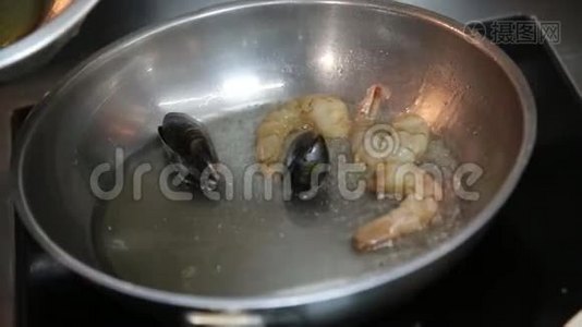 酋长用手把贻贝和鱼放入锅中煮油。视频