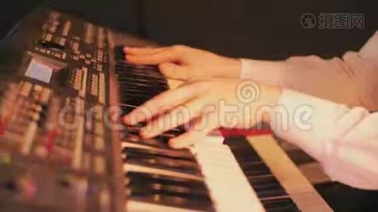 钢琴家的特写`他的手在蓝色灯光的舞台上用键盘弹奏一首歌视频
