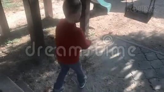 一个男孩在操场上荡空链子秋千。在公园里玩得开心的孩子。视频