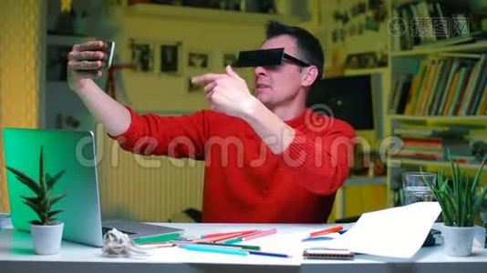办公室桌上一个滑稽的尤图伯正在用智能手机拍摄自己的视频视频