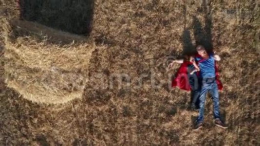 爸爸和儿子超级英雄躺在球场上的俯视图视频