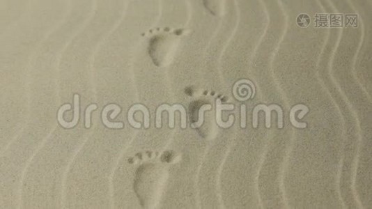 放大。 有花纹的脚印的人，痕迹延伸到远处.. 沙中的脚印..视频