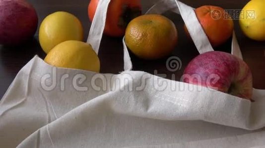 带有产品水果的生态袋。 零废使用少塑概念.. 木制桌子上的生态棉织品袋有机新鲜水果视频