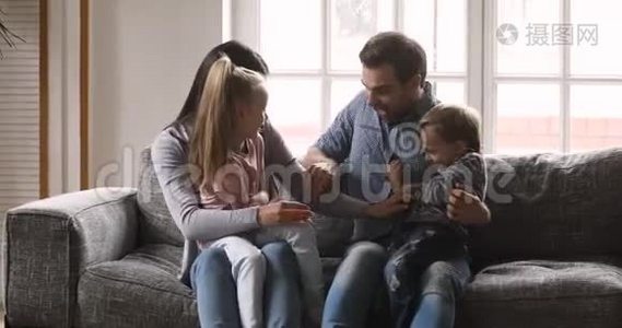快乐的父母和小孩子在沙发上打痒视频
