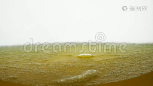 花生油是一种在白色背景下与芝麻油混合的有价值的健康食品。 仔细观察大小视频