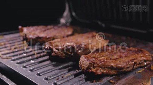 美味多汁的肉排在烤架上烹饪。 陈年珍贵烤大理石牛肉。 电烤炉，迷迭香视频