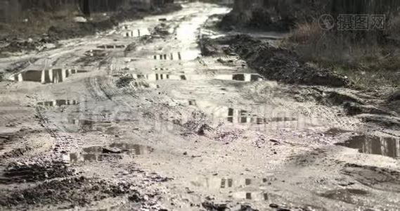 破土烂漫的乡间土路上有许多泥泞的水坑雨后。 运动4k视频，4096x2160片段视频