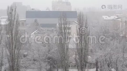 意想不到的降雪席卷了这座城市。 白色蓬松的雪覆盖了广场，街道和房屋的城市景观。视频