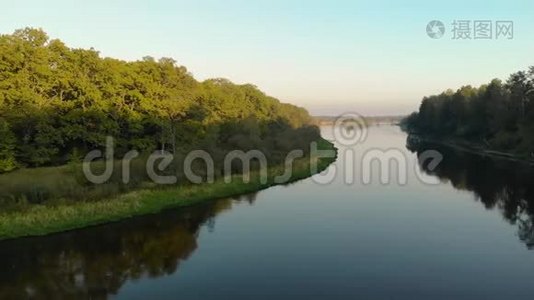 一架无人机在蜿蜒的河流上飞过一个风景名胜区，它反映了巨大而茂密的树木视频