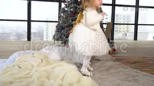 可爱的小女孩躺在床上，身后是圣诞树视频