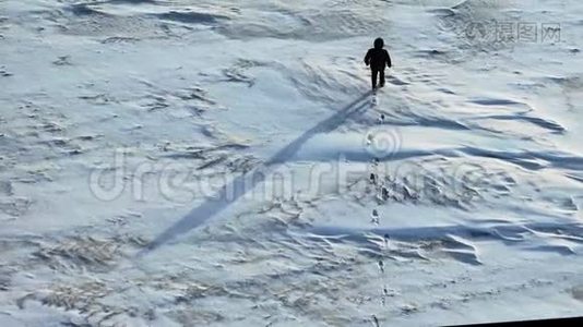 孤独的人走过一片雪白的沙漠。 空中视角。视频