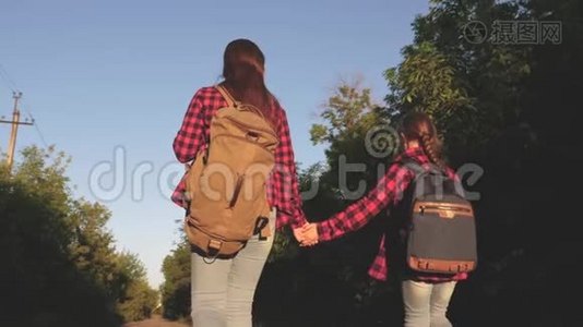 少女旅行牵手.. 徒步旅行者女孩。 儿童旅行者。 带背包的女孩在乡间小路上视频