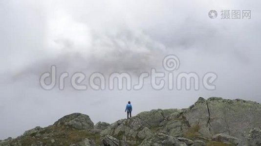 一个孤独的女徒步旅行者站在岩石露头的边缘。视频