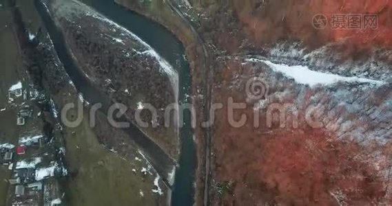 一架无人机在雪岸上的冬天的河流上盘旋视频