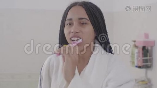 年轻的非洲裔美国妇女与可怕的刷牙肖像。 可爱的少女在早上准备视频