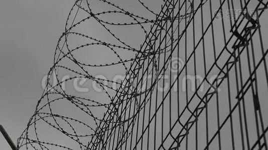 高监狱围栏带刺铁丝网，底景.. 监狱的栅栏挡住了晴朗的天空。 自由概念视频
