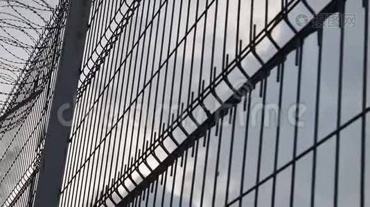 高监狱围栏带刺铁丝网，底景.. 监狱的栅栏挡住了晴朗的天空。 自由概念视频