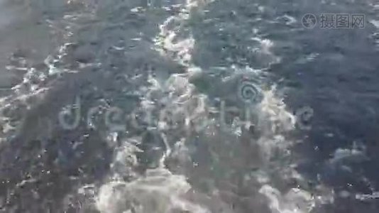 在海上的渡船后面浪着，动作非常慢。视频