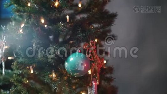 一个男孩在圣诞树上装扮一只圣诞鹿。视频