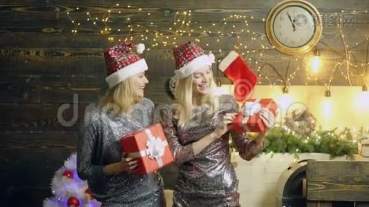 戴着红色圣诞帽和闪亮连衣裙的女人带着红色的礼品盒，微笑着，欢欣鼓舞。 圣诞庆典视频