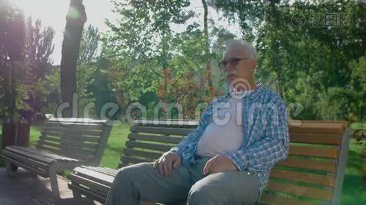 祖父在公园的长椅上等着他的孙子视频