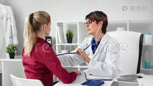自信的女医生用听诊器给年轻女孩均匀的听力呼吸视频