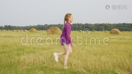 可爱的女孩奔跑乡村田野干草堆夏日风景视频