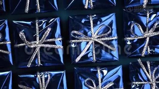 蓝色背景上移动蓝色礼品盒。 圣诞节和新年的旋转背景。 现在，惊喜的概念视频